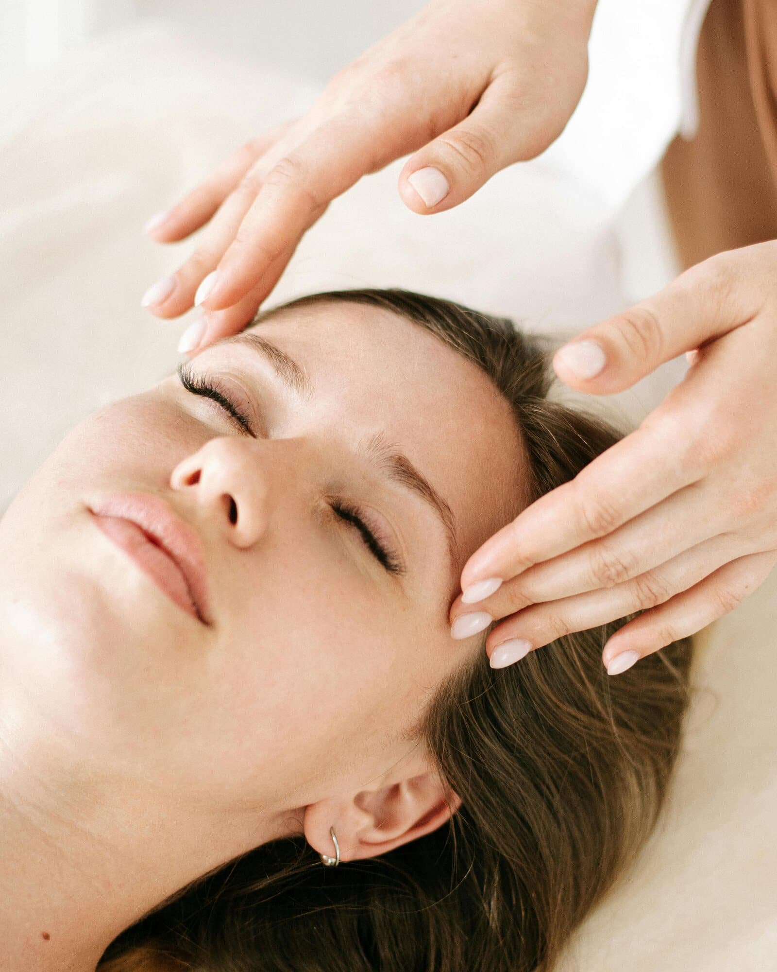 Massagem facial na Sense Clinic — as mãos de uma profissional da casa sobre o rosto de uma cliente